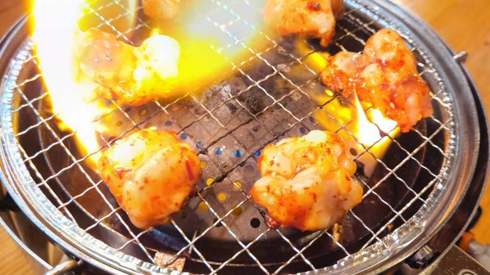 炎が上がる網のホルモン焼き